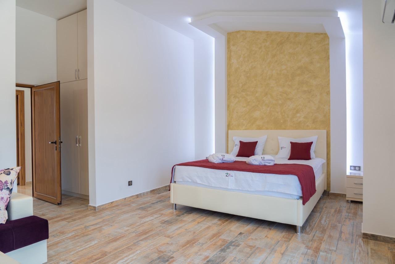 Elegant modern bedroom in Ulcinj with double bed, sleek finishes, open closet&mdash;ideal Montenegro investment. Montenegro-listings.me by Ekosphere.