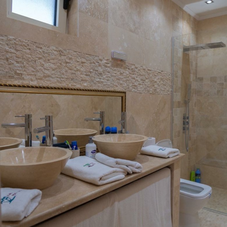 Elegant modern bathroom in Ulcinj real estate, tiled, dual vessel sinks, glass shower; exclusive on immorenta.me by ekosphere doo.