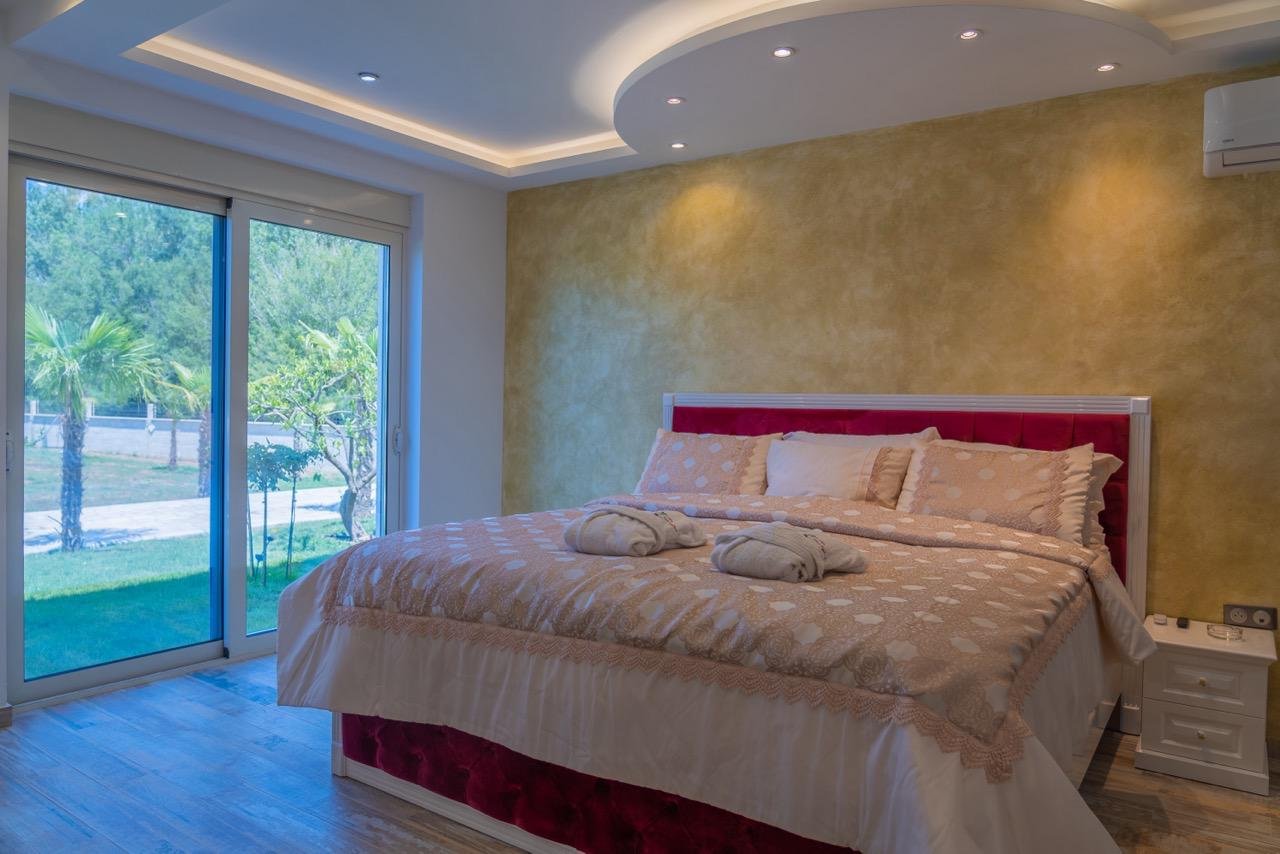 Modern Ulcinj bedroom by Ekosphere: gold accent wall, glass doors, designer lighting. Invest via immorenta.me today.