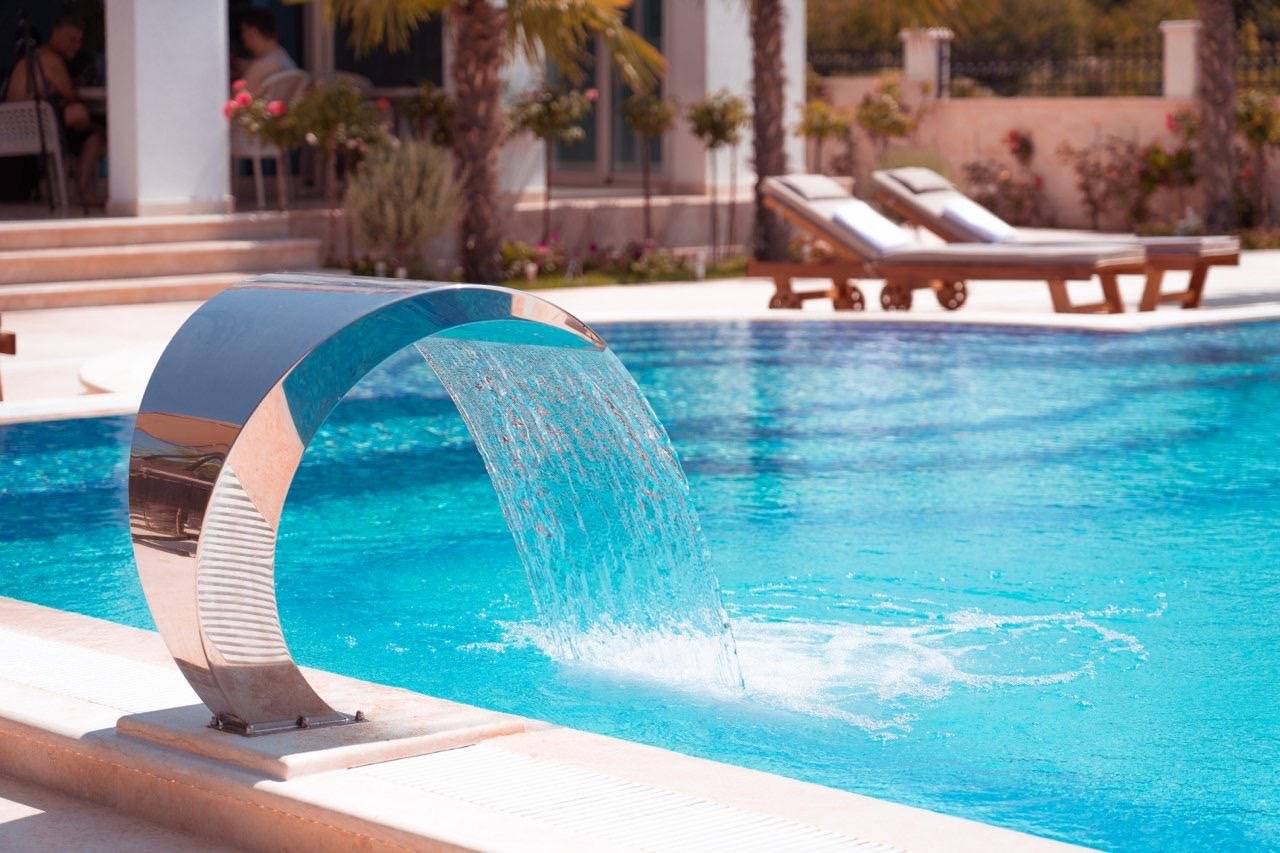 Luxury Ulcinj villa: sleek pool, waterfall feature, palm trees, stylish lounges&mdash;exclusive Montenegro real estate by Ekosphere | immorenta.me.