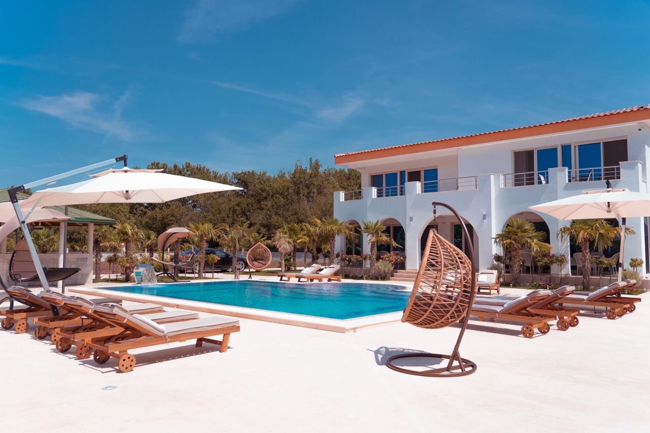 Luxurious modern villa with pool, lush palms, and spacious balconies in Ulcinj&mdash;exclusive Ekosphere DOO listing on immorenta.me.