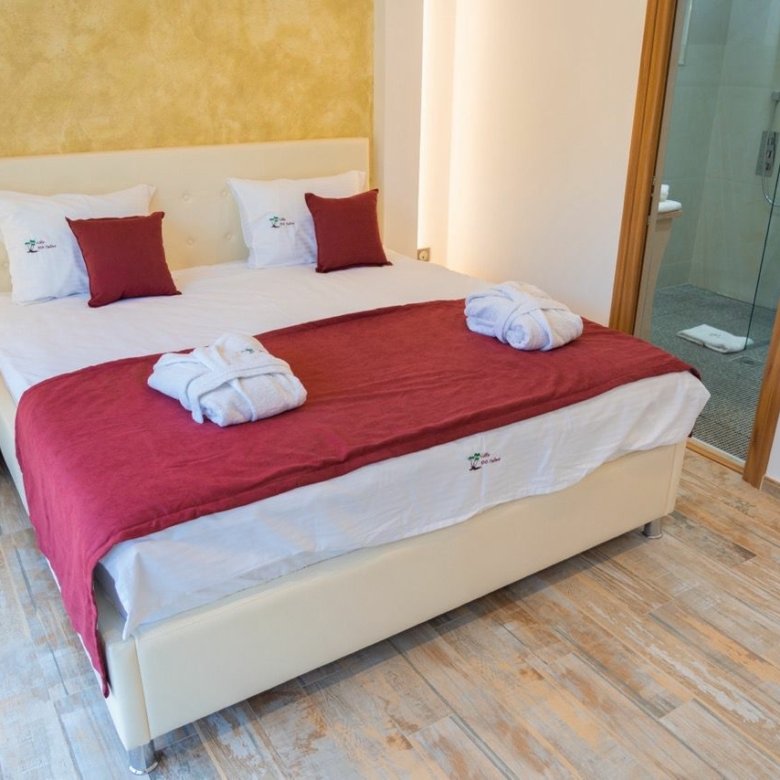 Modern Ulcinj bedroom with stylish red bedding, white headboard, ensuite bath&mdash;ideal investment via immorenta.me by ekosphere doo.