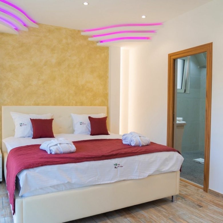 Stylish Ulcinj hotel room with luxury bed, chic lighting, gold accent wall, and ensuite&mdash;ideal for property investors via immorenta.me by ekosphere doo.