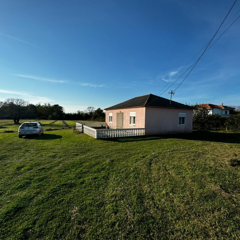 Charming light pink house with red roof on a lush lawn, Ulcinj&mdash;ideal Montenegro property investment. Exclusive to immorenta.me by ekosphere doo.