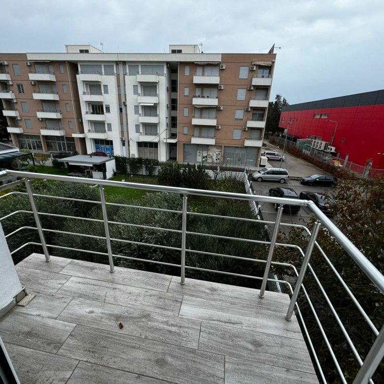 Modern tiled balcony with metal railings, city views of Ulcinj, Montenegro. Prime real estate near ekosphere doo. Invest today!.