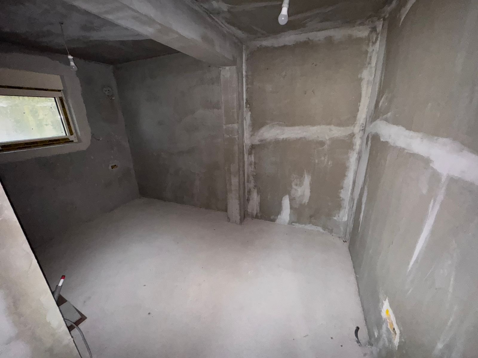Unfinished room with concrete walls, small window&mdash;prime Ulcinj investment on immorenta.me by Ekosphere doo.