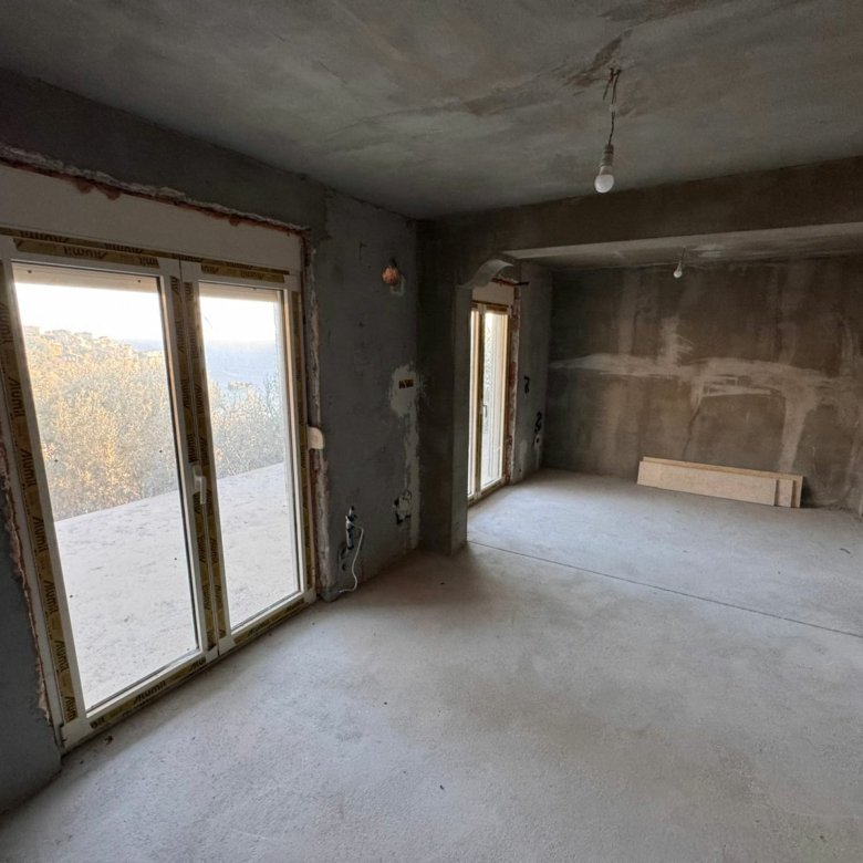 Spacious unfinished room with concrete floors, large glass doors, and prime potential for investment in Ulcinj by ekosphere doo.