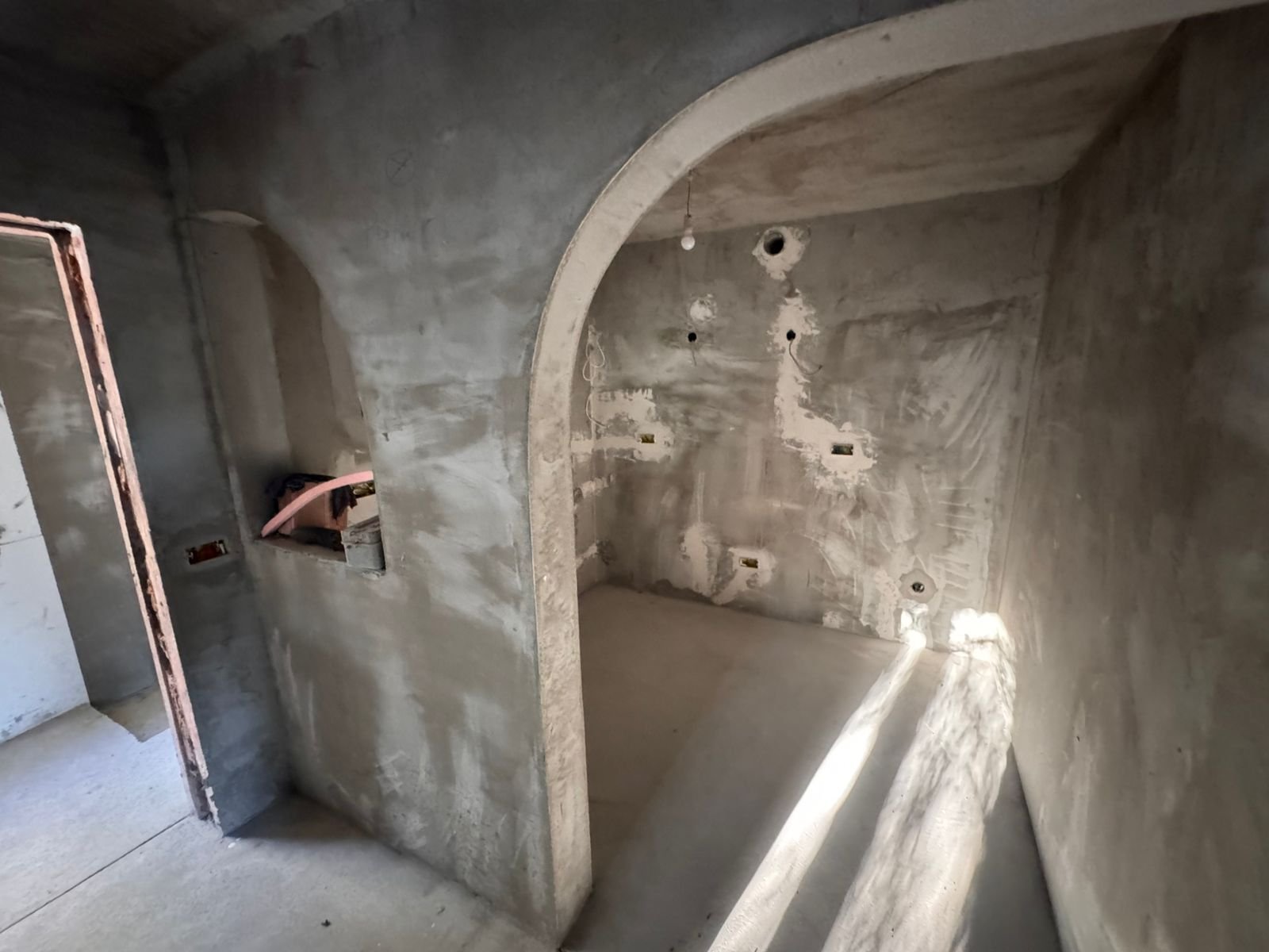 Spacious unfinished room with arched doorway and sunlight, ideal for investment in Ulcinj. Exclusive at immorenta.me by ekosphere doo.