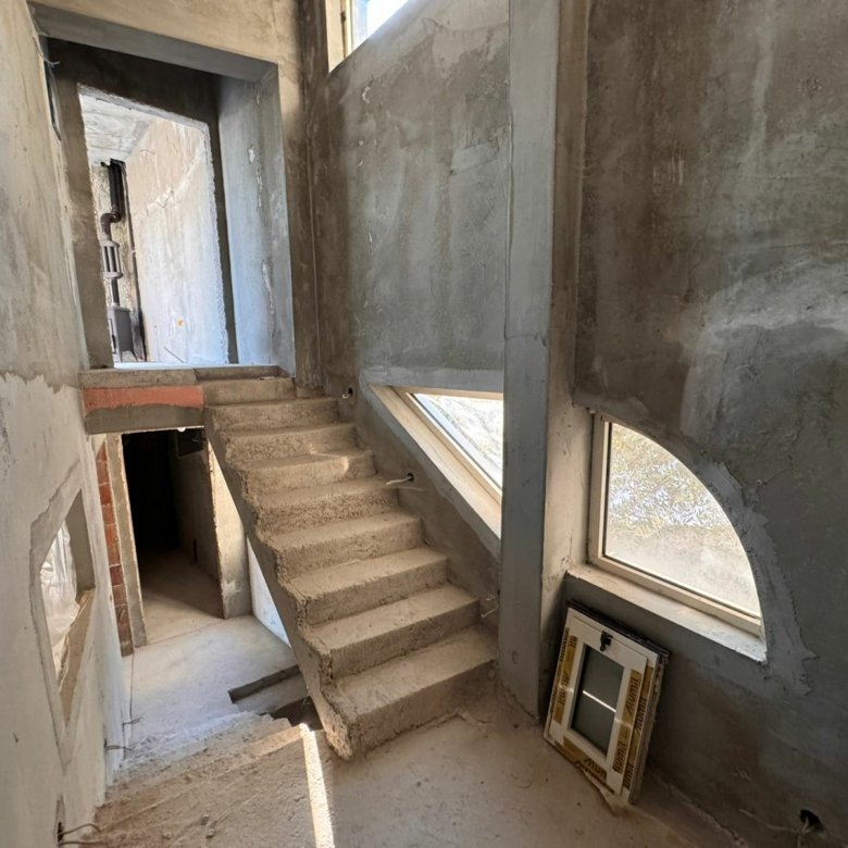 Spacious unfinished interior in Ulcinj, Montenegro with concrete stairs and arched windows&mdash;prime investment via immorenta.me by Ekosphere doo.