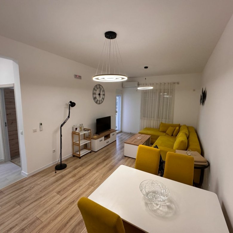 Stylish modern living-dining space in Ulcinj, Montenegro with wood floors, designer sofa&mdash;exclusive on immorenta.me by Ekosphere.