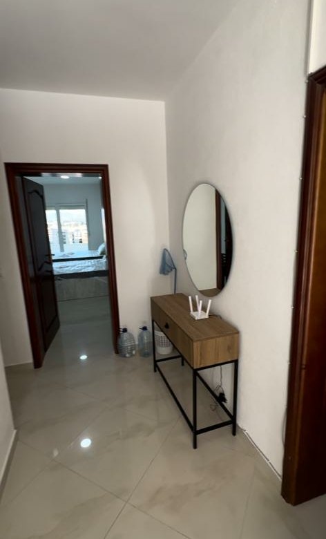 Elegant hallway in Ulcinj real estate with glossy tiles, stylish console, mirror, open to a cozy bedroom&mdash;immorenta.me by ekosphere doo.