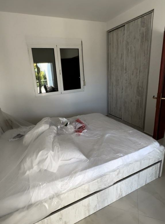 Spacious Ulcinj bedroom with tiled floors, large white bed, ample wardrobe, bright window&mdash;ideal Montenegro investment by ekosphere doo.