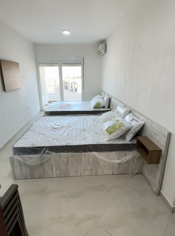 Bright Ulcinj bedroom with twin beds, balcony access, and modern furnishings&mdash;prime investment on immorenta.me by ekosphere doo.