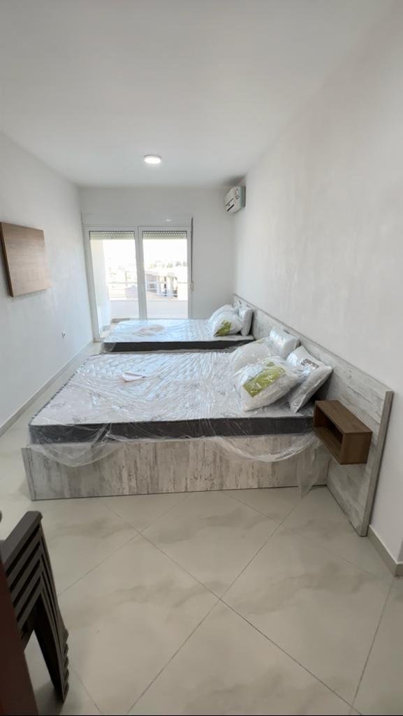 Bright Ulcinj bedroom with twin beds, balcony access, and modern furnishings&mdash;prime investment on immorenta.me by ekosphere doo.