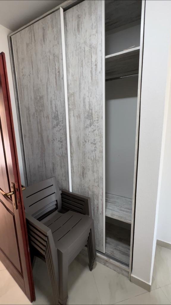 Modern wood-finish wardrobe, light tiled floors, and stacked chairs enhance this Ulcinj property&mdash;exclusive with immorenta.me by ekosphere doo.