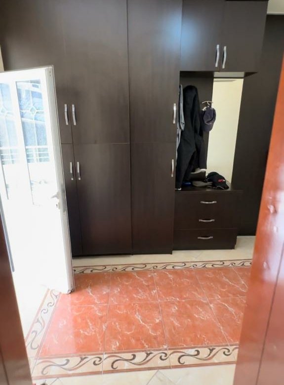 Spacious dark brown wardrobe with versatile storage, modern tiles, and bright open-door lighting&mdash;ideal for Ulcinj investments. Montenegro-listings.me by ekosphere doo.
