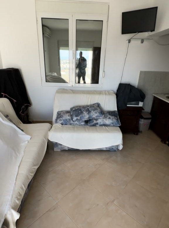 Modern tiled-floor room for sale in Ulcinj, Montenegro: bright space, white loveseat, TV&mdash;ideal property at immorenta.me by ekosphere doo.