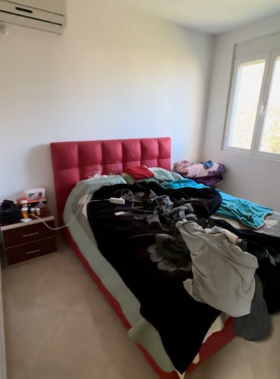 Modern Ulcinj bedroom with red tufted headboard, natural light, AC unit; top Montenegro property at immorenta.me by Ekosphere.