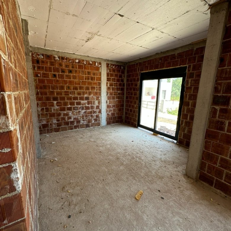 Spacious unfinished room in Ulcinj, Montenegro. Brick walls, concrete floor, sliding glass door. Exclusive on immorenta.me by Ekosphere DOO.