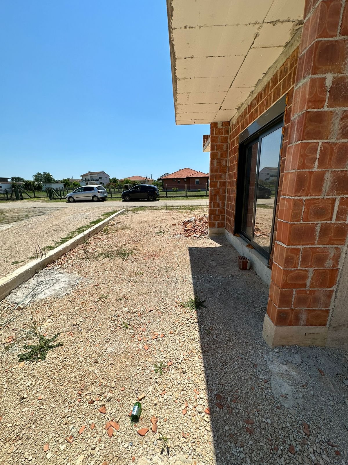 Modern brick building by Ekosphere with glass doors, gravel yard, and Ulcinj real estate views&mdash;exclusive at immorenta.me.