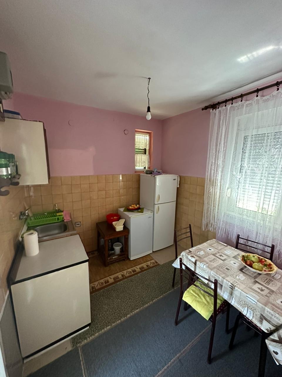 Charming Ulcinj kitchen with pink walls, brown tiles, appliances, dining set&mdash;ideal investment. Exclusive at immorenta.me by ekosphere doo.