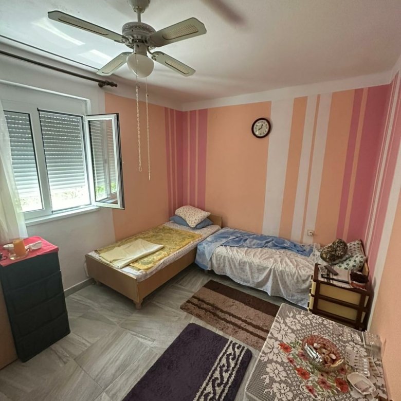 Charming Ulcinj bedroom: 2 single beds, ceiling fan, bright window, ideal for investment. Listed on immorenta.me by Ekosphere DOO.