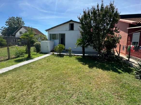 Charming white house with glass door on lush lawn, prime Ulcinj location near amenities&mdash;exclusive at immorenta.me by ekosphere doo.