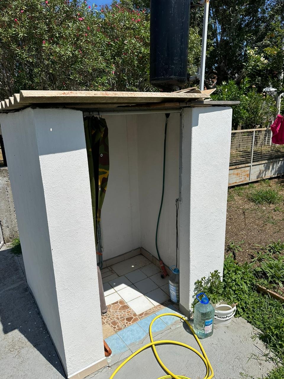 Modern outdoor shower with white walls, tiled floor, eco water tank&mdash;ideal Ulcinj property investment. By ekosphere doo on immorenta.me.