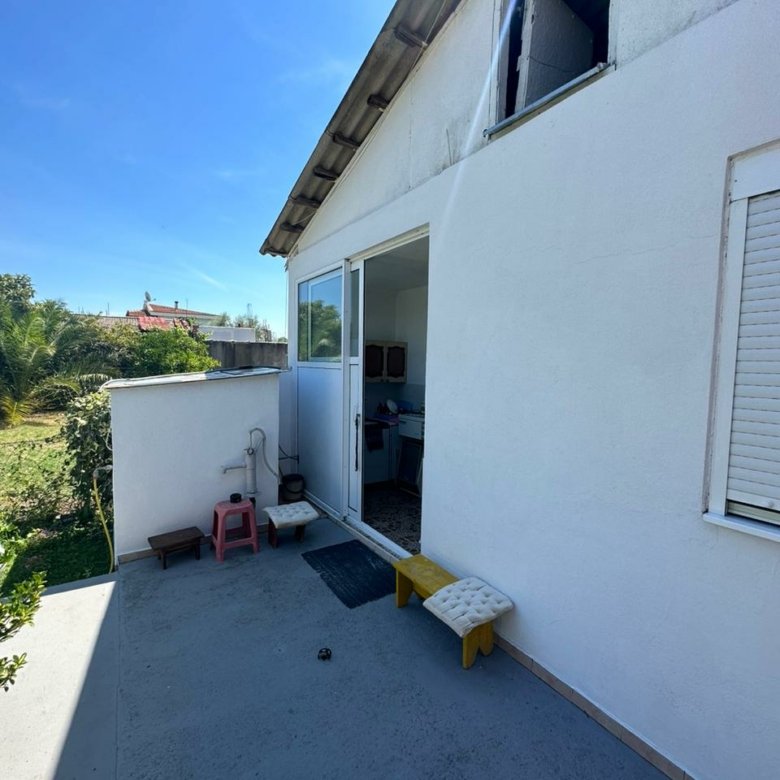 Sunny patio in Ulcinj, Montenegro with stylish seating, sliding glass door, and ekosphere-inspired interior&mdash;exclusive on immorenta.me.