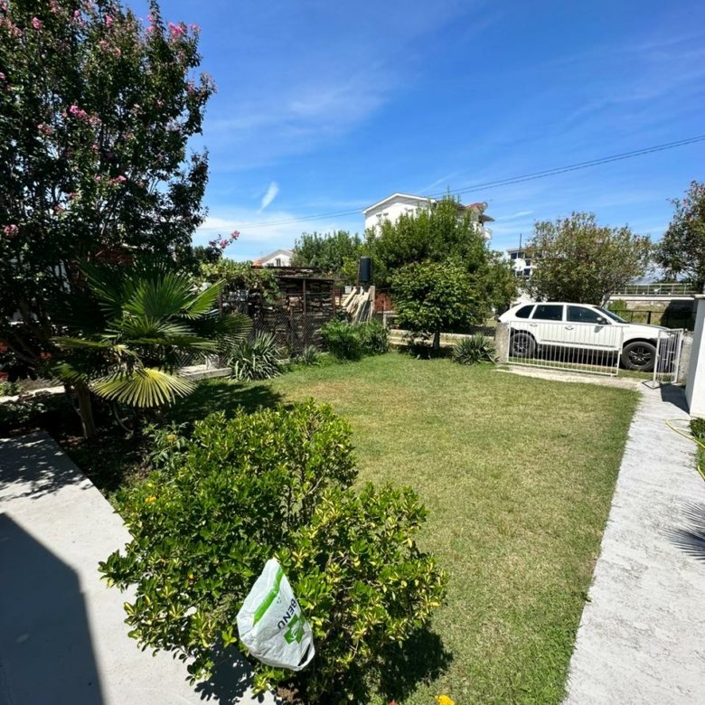 Discover this Ulcinj Montenegro property: lush lawn, mature trees, gated access, and prime curb appeal. Invest via immorenta.me by ekosphere doo.