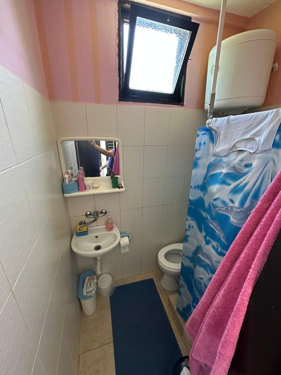 Bright bathroom in Ulcinj property: white tiles, sink with mirror, shower, window. Invest via immorenta.me by Ekosphere doo.
