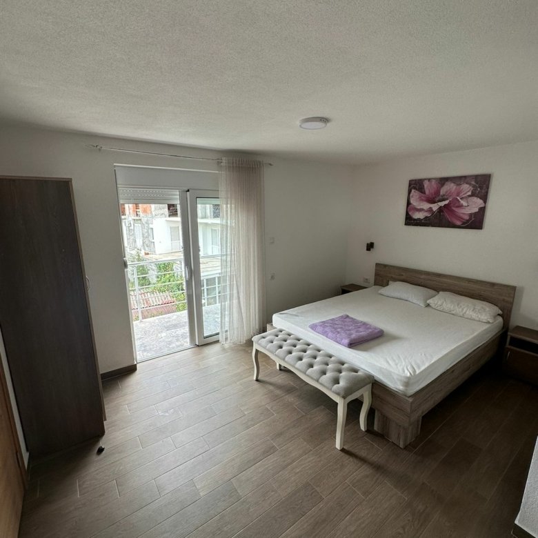 Luxury Ulcinj bedroom with double bed, bench, wardrobe, and bright window. Invest in Montenegro real estate&mdash;Ecosphere quality by immorenta.me.