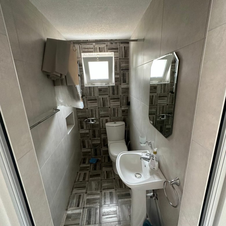 Modern tiled bathroom featuring natural light, quality fixtures, ideal for Ulcinj Montenegro real estate on immorenta.me by Ekosphere.