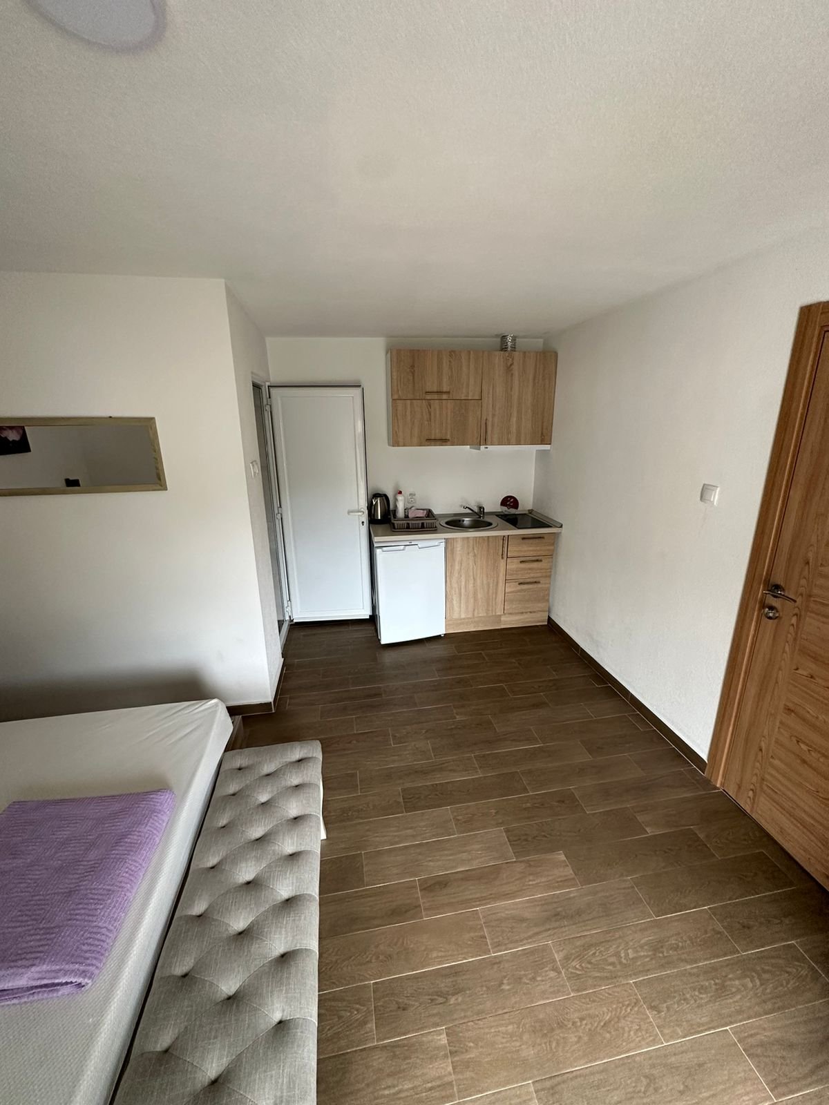 Modern studio in Ulcinj with bed, kitchenette, wood cabinets, appliances & flooring. Ideal Montenegro real estate by ekosphere doo.