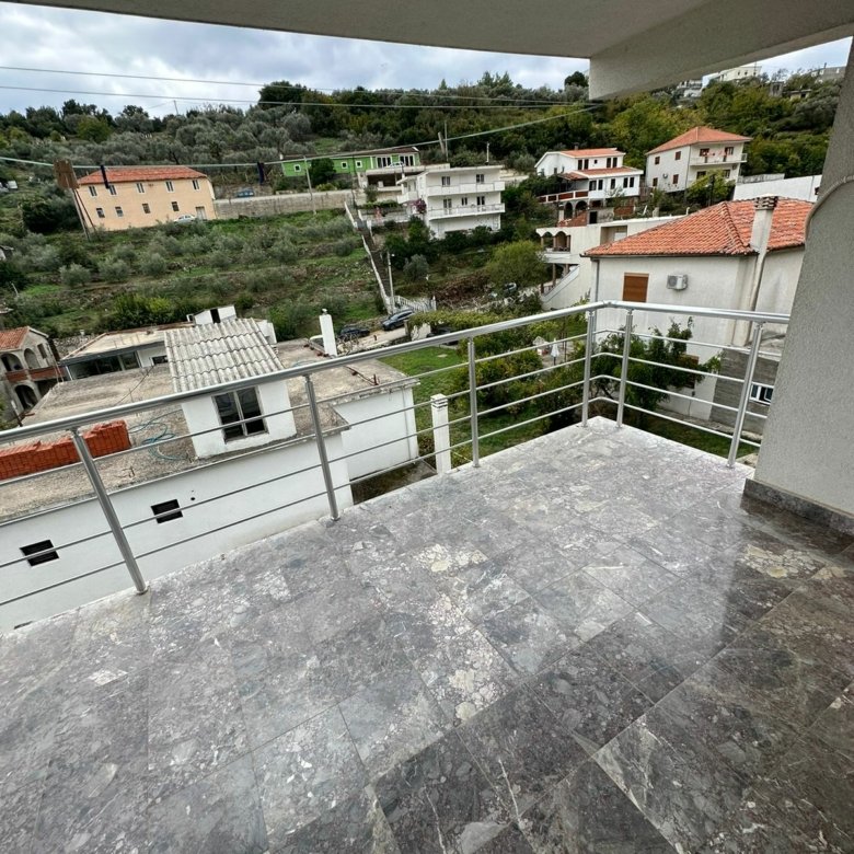 Spacious tiled balcony with metal railing, panoramic Ulcinj views of white and red-roofed homes, ideal for investment. Montenegro-listings.me by ekosphere doo.