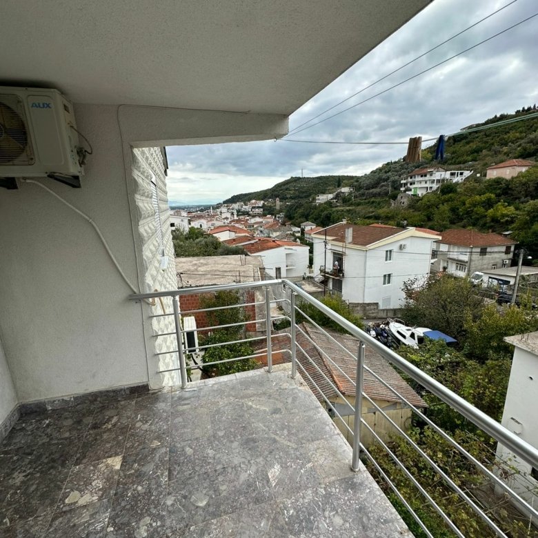 Modern marble-floored balcony with scenic Ulcinj views&mdash;red-tile roofs, lush hills. Exclusive at immorenta.me by Ekosphere Doo.