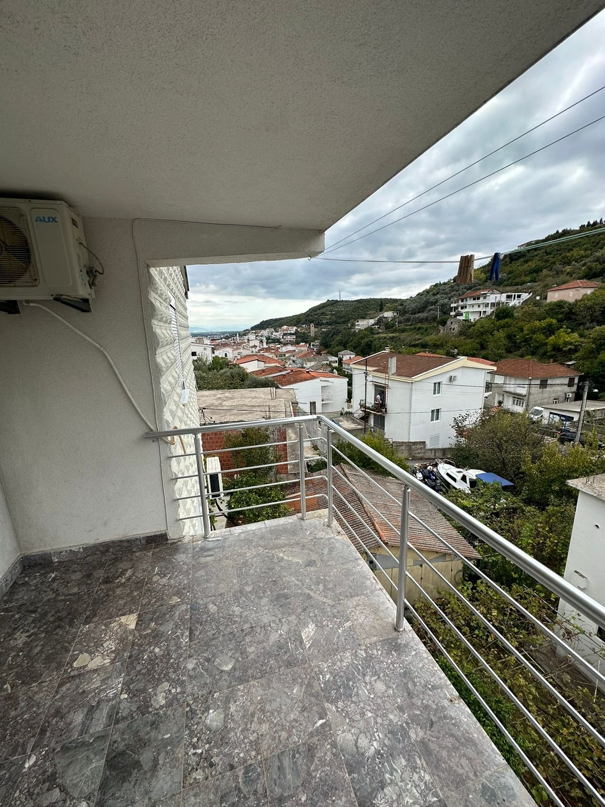 Modern marble-floored balcony with scenic Ulcinj views&mdash;red-tile roofs, lush hills. Exclusive at immorenta.me by Ekosphere Doo.