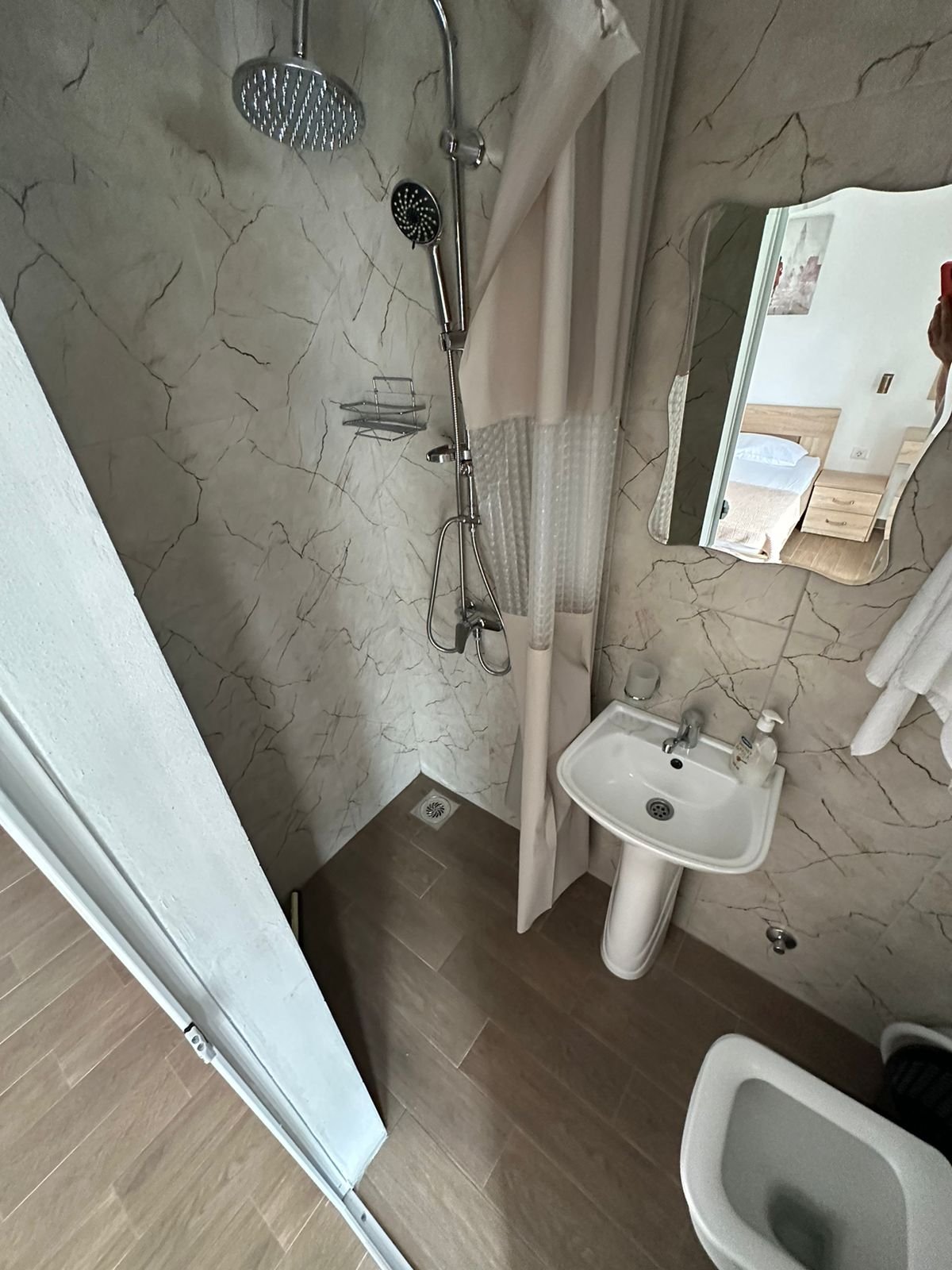 Modern bathroom in Ekosphere&rsquo;s Ulcinj property: rainfall shower, elegant sink, quality fixtures&mdash;ideal real estate investment.