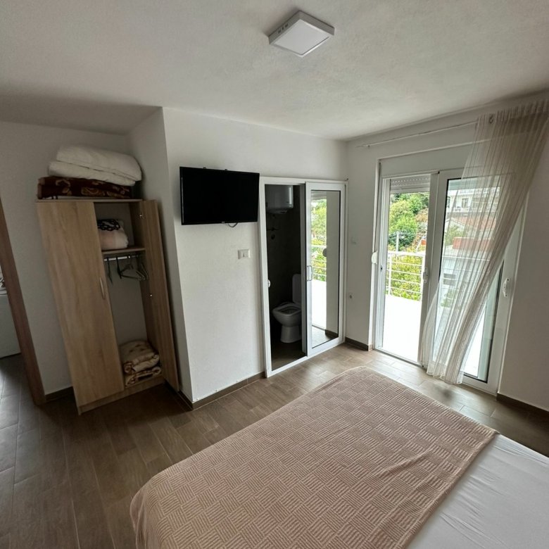 Elegant Ulcinj, Montenegro bedroom with balcony, lush views. Invest via immorenta.me by Ekosphere doo&mdash;prime real estate!.