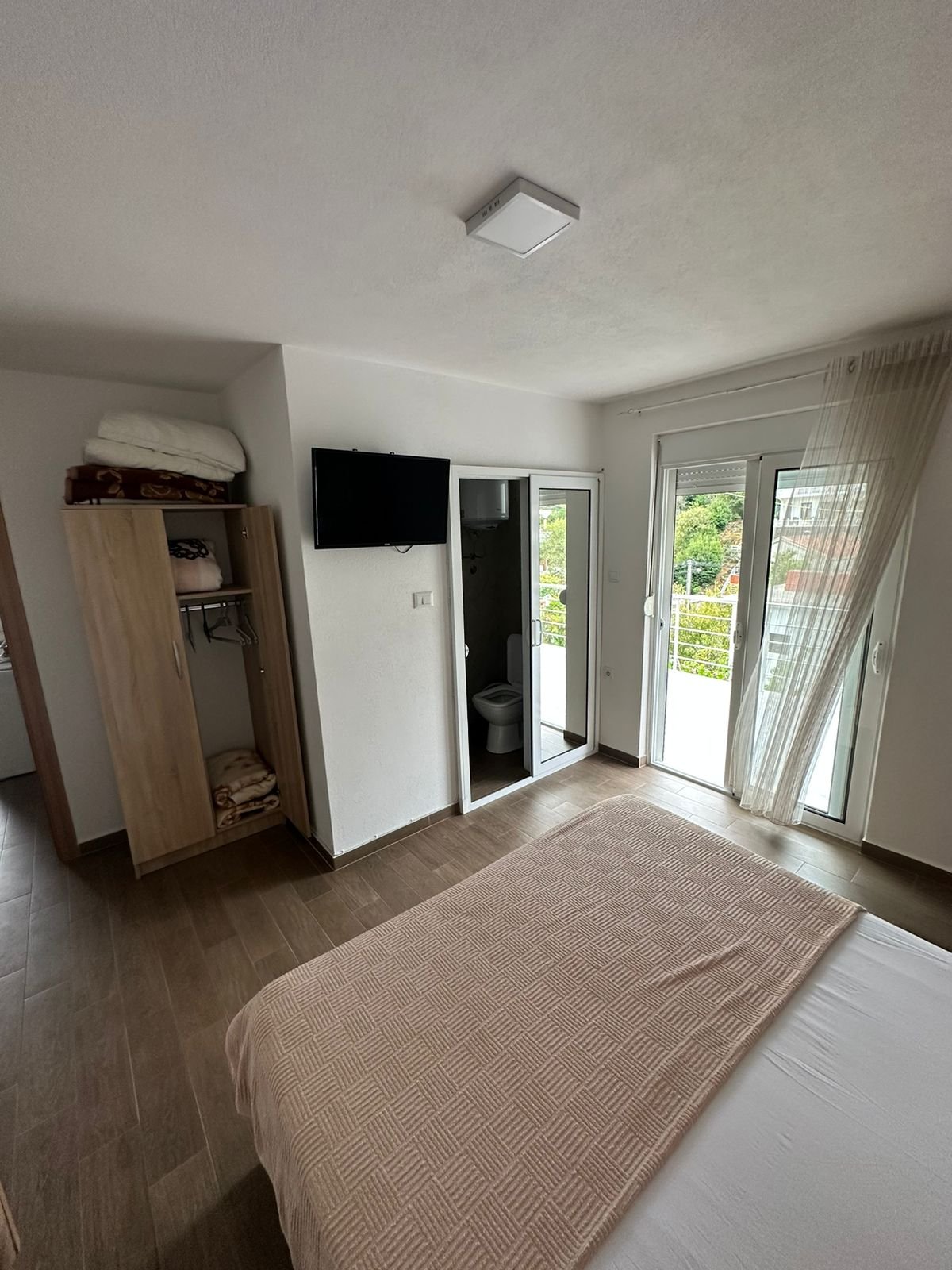 Elegant Ulcinj, Montenegro bedroom with balcony, lush views. Invest via immorenta.me by Ekosphere doo&mdash;prime real estate!.