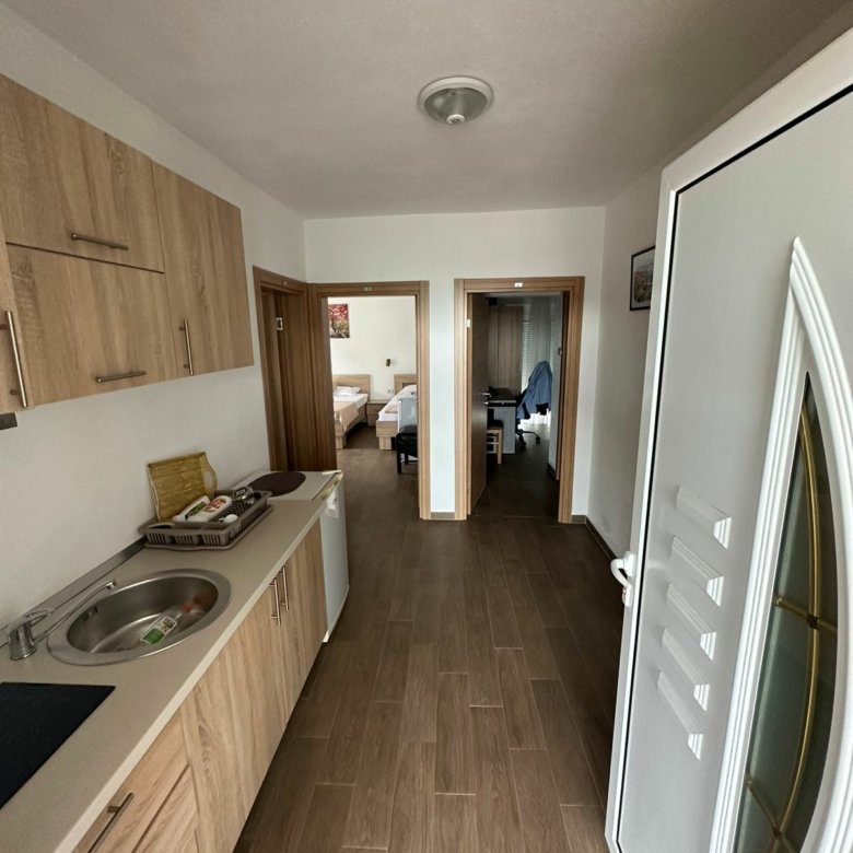 Modern Ulcinj apartment: stylish hallway with eco wood-tile floors, kitchenette, and furnished bedrooms. Exclusive at immorenta.me by ekosphere doo.