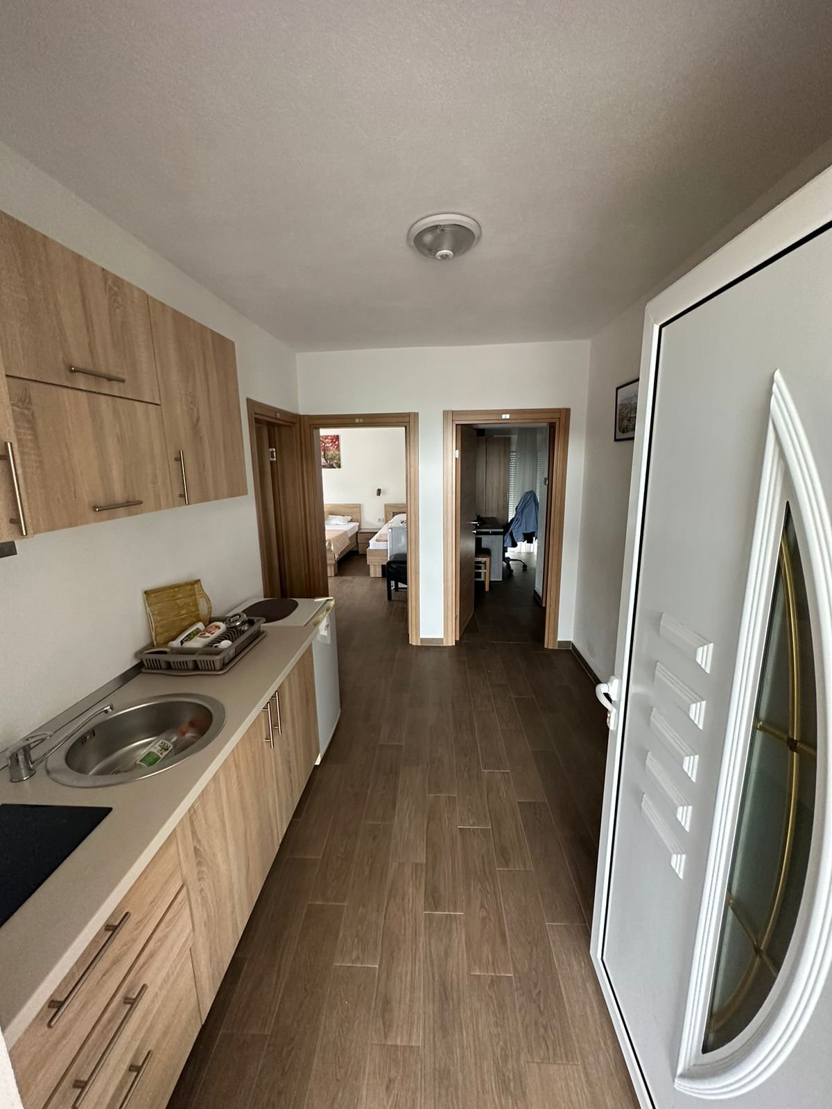 Modern Ulcinj apartment: stylish hallway with eco wood-tile floors, kitchenette, and furnished bedrooms. Exclusive at immorenta.me by ekosphere doo.