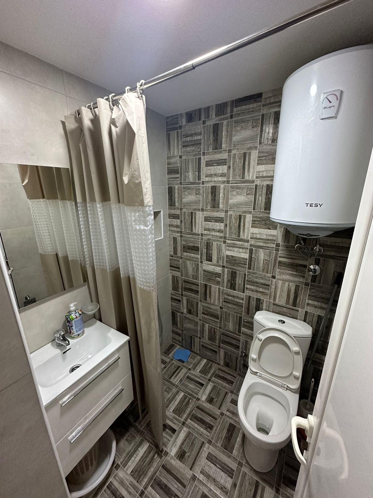 Modern bathroom in Ulcinj real estate by Ekosphere doo, Montenegro: patterned tiles, sink, shower, heater. immorenta.me.