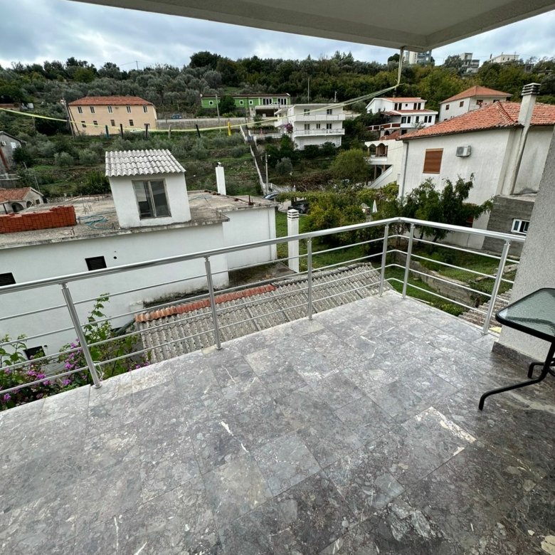Spacious tiled balcony in Ulcinj with metal railing, glass table, lush views&mdash;ideal for investors. Featured on immorenta.me by ekosphere doo.