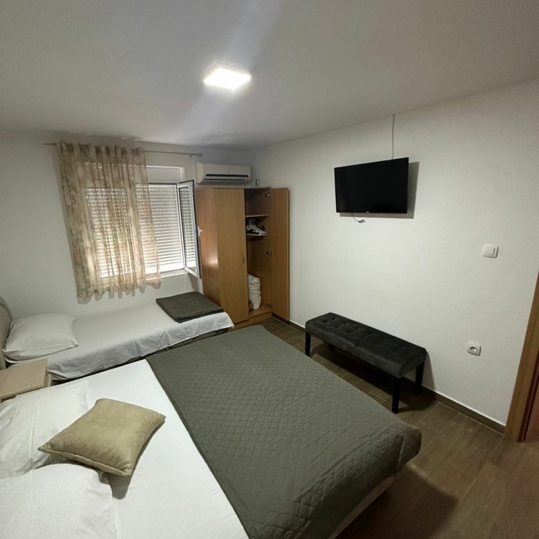 Modern Ulcinj bedroom with double and single beds, TV, wood floors&mdash;prime real estate by ekosphere doo at immorenta.me.