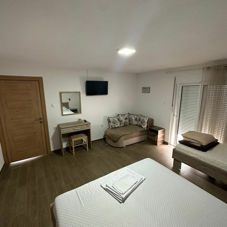 Modern Ulcinj property with stylish furnishings: bed, desk, sofa, TV & balcony&mdash;ideal Montenegro real estate by ekosphere doo.