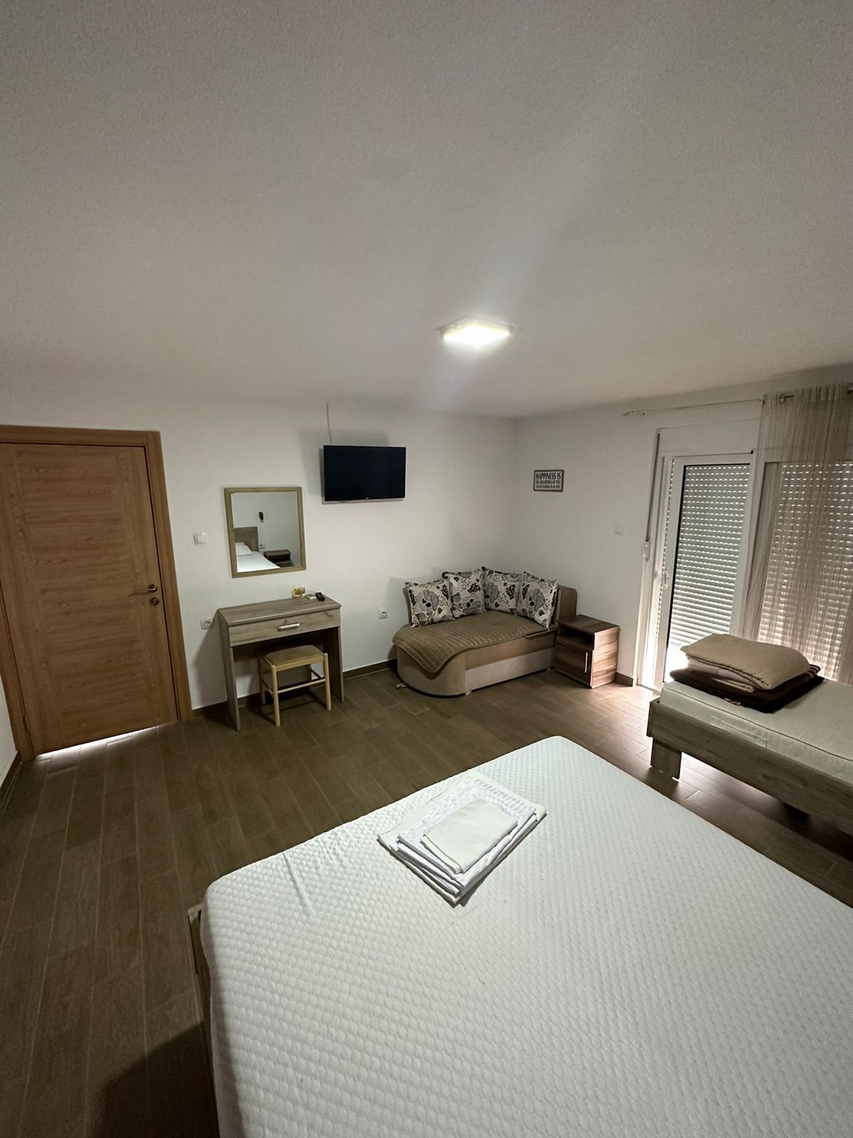 Modern Ulcinj property with stylish furnishings: bed, desk, sofa, TV & balcony&mdash;ideal Montenegro real estate by ekosphere doo.