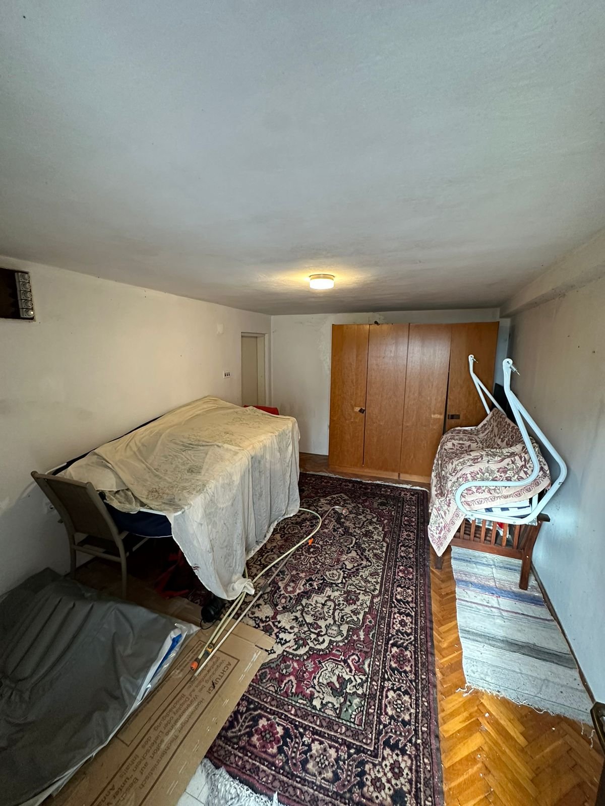 Charming Ulcinj property: compact room with white walls, wardrobe, sofa, unique features&mdash;exclusive on Montenegro-Listings by Ekosphere.