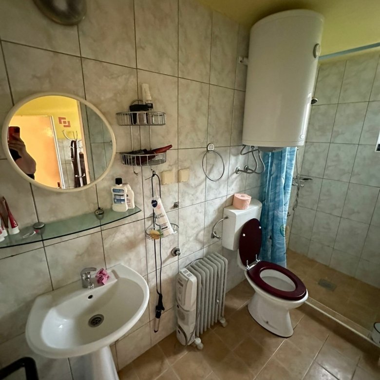 Modern tiled bathroom in Ulcinj property, walk-in shower, pedestal sink, heater; ideal real estate by Ekosphere & immorenta.me.