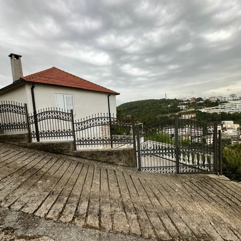 Investment opportunity in Ulcinj: Modern home with red-tile roof, fenced yard, driveway, and panoramic views. Montenegro-listings.me by ekosphere doo.
